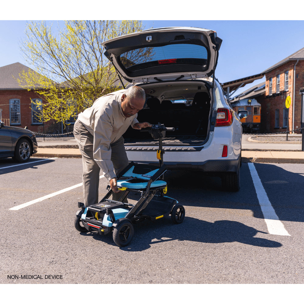 Mint Color Pride Go Go® Super Portable Mobility Scooter being carried to the back of the Car