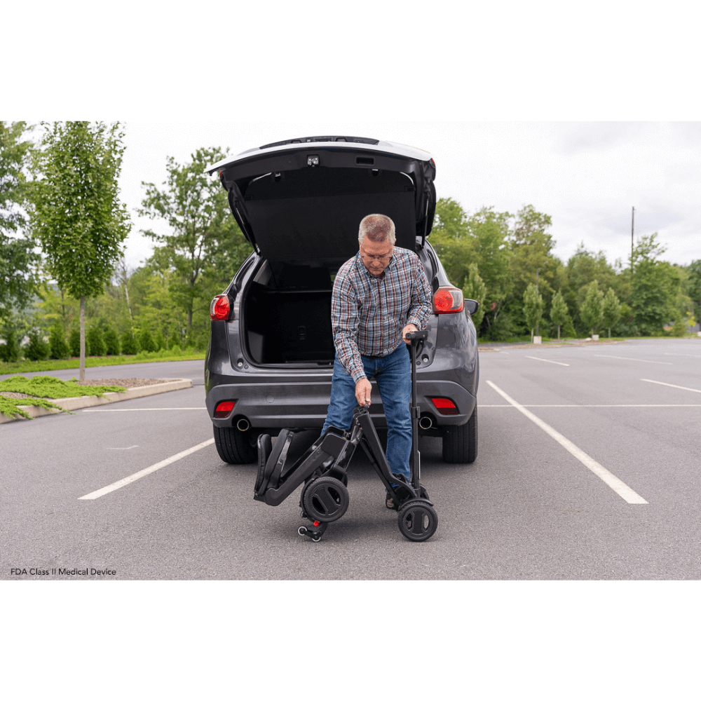 Pride Go Go® Carbon Quick Fold Scooter being carried to the back of the Car