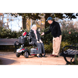 A Man Talking to an Elderly Woman Seated on the Drive Medical Ventura 4-Wheel Mobility Scooter in a Park