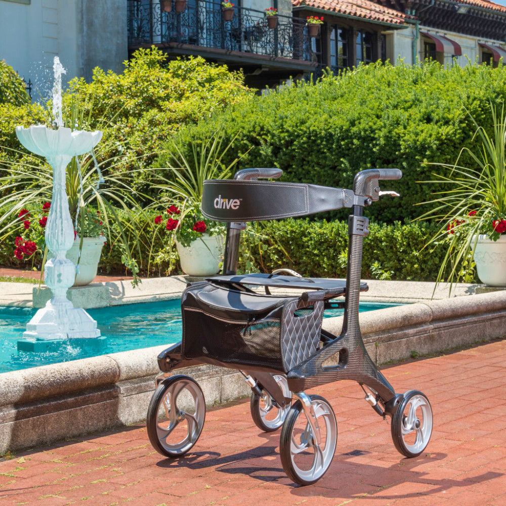 Drive Medical Nitro Elite Carbon Fiber Rollator Displayed Outdoors near a Fountain