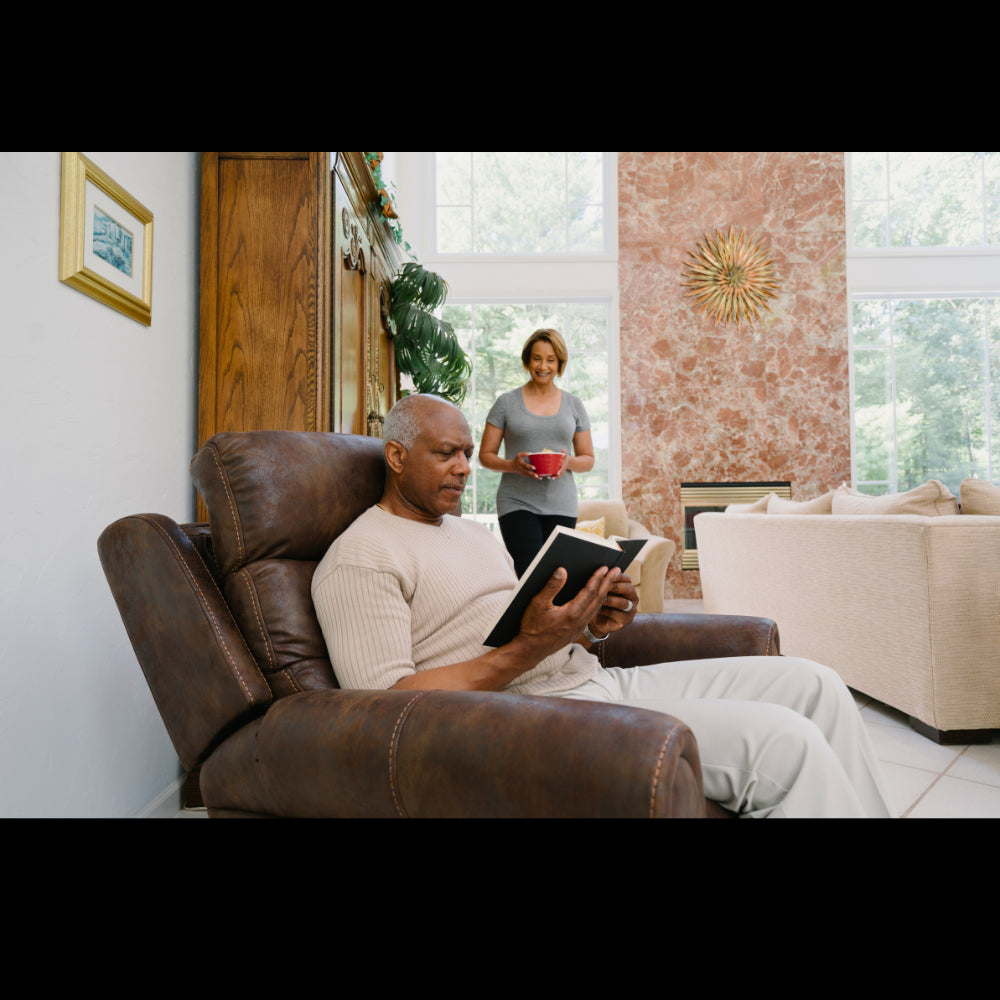 Elderly man reading a book while sitting in a Pride Mobility VivaLift Tranquil 2 PLR-935 Lift Chair 