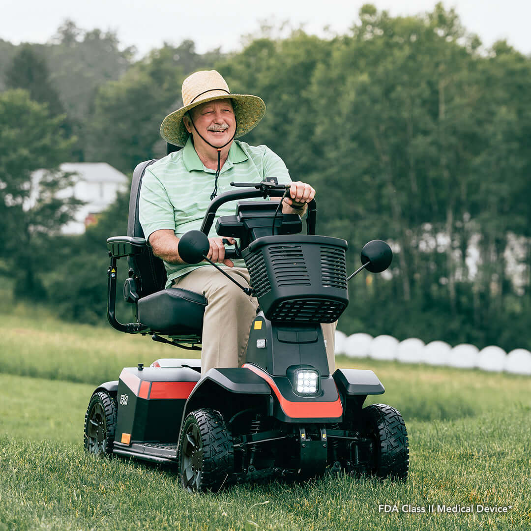Red Color Pride PX4 All Terrain Mobility Scooter - A Man Riding the scooter in a Grassy Area