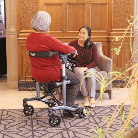 Triumph Mobility Escape Mini Compact Folding Rollator - Lady sitting on the rollator talking to a friend
