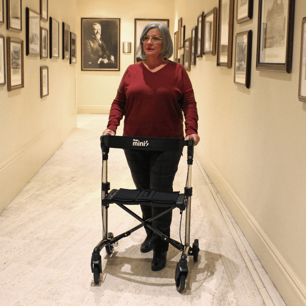 Triumph Mobility Escape Mini Compact Folding Rollator - Lady in an Art Gallery using the Rollator